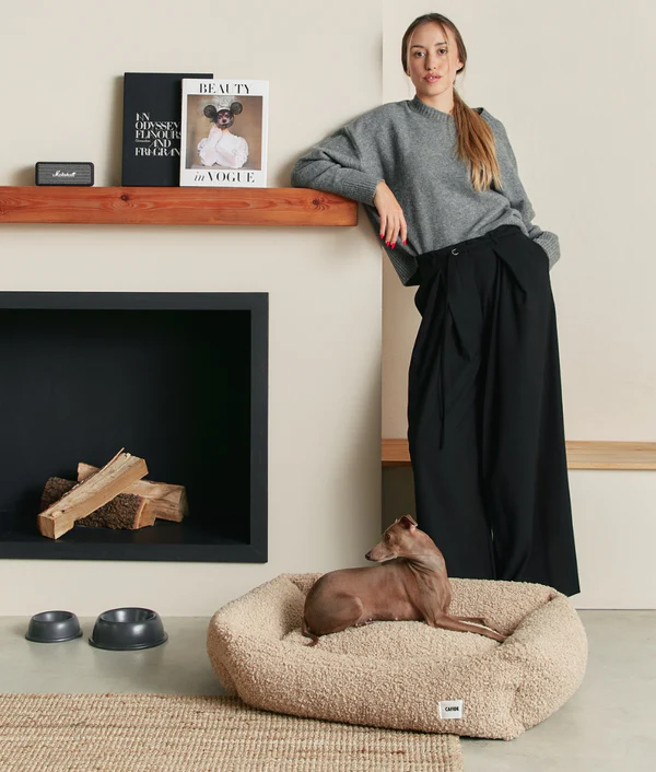 Legowisko dla psa w beżowym kolorze, materiał wierzchni to imitacja owczej wełny,, miękkie i przytulne, z wysokimi bokami i wyjmowaną poduszką – Fine and Furry.