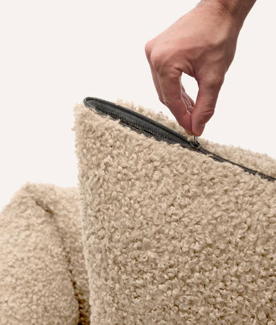 Legowisko dla psa w beżowym kolorze, materiał wierzchni to imitacja owczej wełny,, miękkie i przytulne, z wysokimi bokami i wyjmowaną poduszką – Fine and Furry.